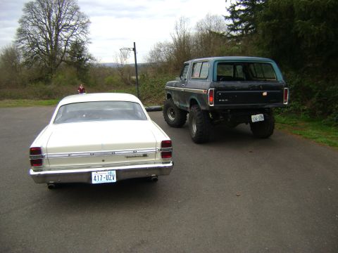 1967 Ford Fairlane - A lifted Ford Bronco is parked behind a white Ford Fairlane, both facing away from the camera.
