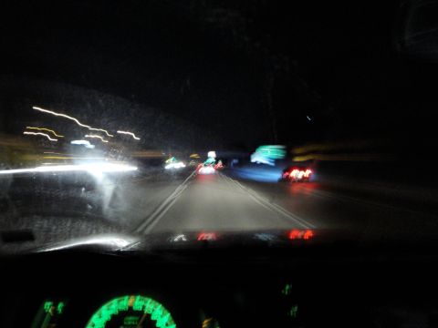 1989 Ford Taurus - View from inside a vehicle at night, showing the dashboard and blurred lights of traffic on the highway.