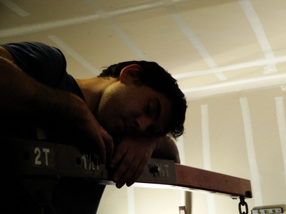 guy passed out on a piece of equipment with '2T' and '1 1/2T' markings