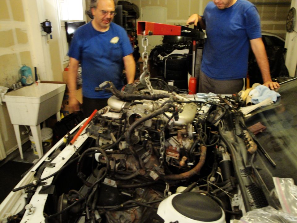 Engine being lifted out of a car with an engine hoist