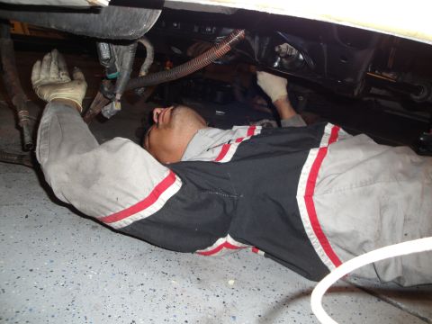1989 Ford Taurus - A mechanic performs work on the engine or undercarriage of a vehicle.