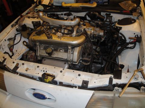 1989 Ford Taurus - Engine bay of a 1989 Ford Taurus, with the engine in a state of disassembly.