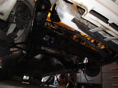 1989 Ford Taurus - The underside of a vehicle is shown, revealing suspension parts and the exhaust system.