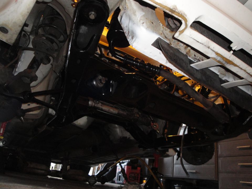 Undercarriage view of a vehicle with suspension components and exhaust system visible