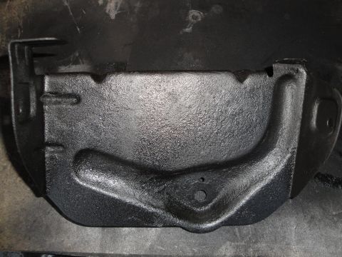 1989 Ford Taurus - A close-up view of a black, textured engine oil pan, possibly recently painted.