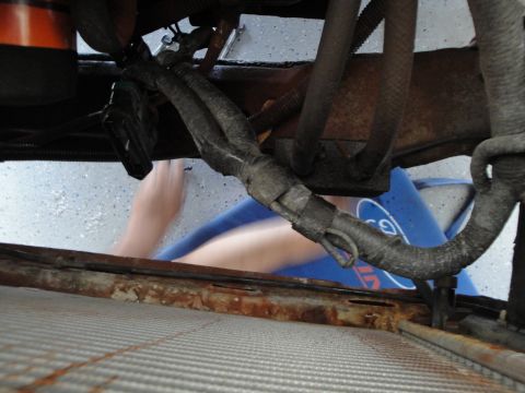 1989 Ford Taurus - A person's arms are visible working in the engine bay of a vehicle, with focus on the radiator and engine components.