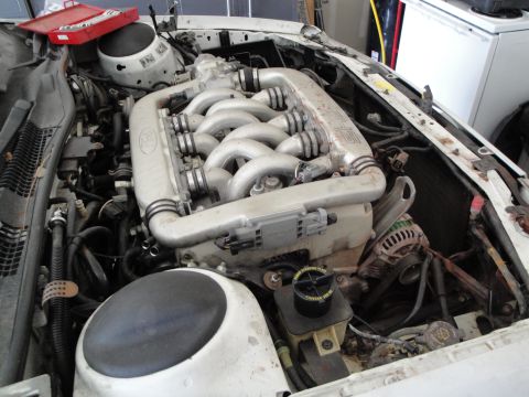 1989 Ford Taurus - Engine bay view showing a V-shaped intake manifold with a Ford logo, likely from a non-Taurus vehicle.