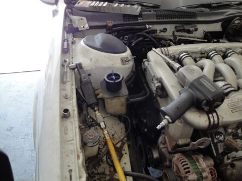 1989 Ford Taurus - Air tools are staged in the engine bay, ready for an engine swap or repair.