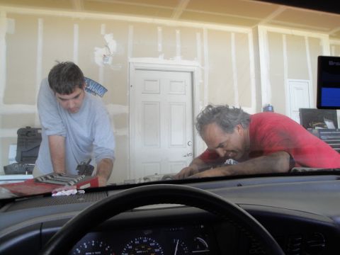 1989 Ford Taurus - Mechanics are busy with an engine repair in a garage setting.