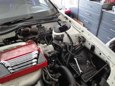 1989 Ford Taurus - A red toolbox filled with wrenches sits in the engine bay, with a single wrench resting on the air filter housing.