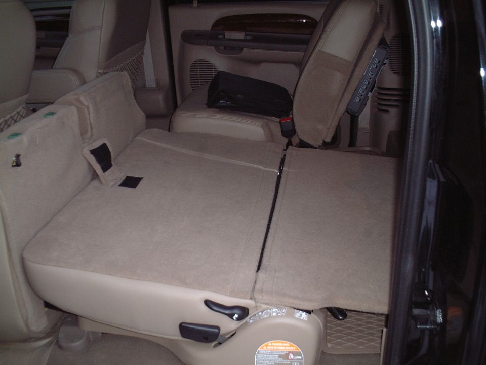 Tan SUV interior with rear seats folded flat and door open