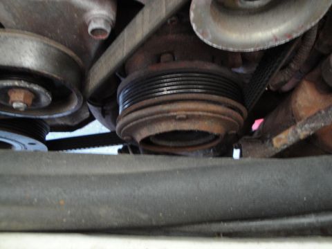 1989 Ford Taurus - Close-up view of engine pulleys and belts, showing signs of wear and rust.
