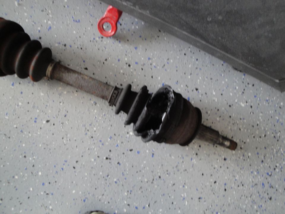 Damaged CV axle with torn boot and visible internal components