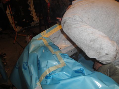 1989 Ford Taurus - Mechanic works on the interior of a vehicle, using protective sheeting and tape.