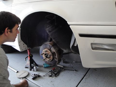 1989 Ford Taurus - Car brake repair in progress, with tools laid out on the garage floor.