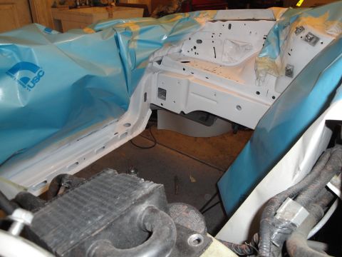 1989 Ford Taurus - The engine bay is covered in protective sheeting, revealing a white primer coat during what appears to be a restoration or repair process.