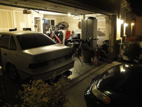 1989 Ford Taurus - Rear view of a 1989 Ford Taurus inside a garage with various items stored around it.