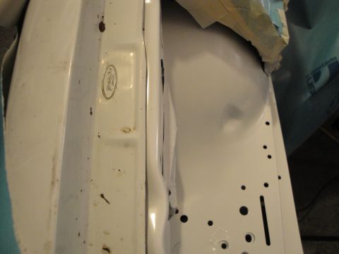 1989 Ford Taurus - A Ford emblem is visible on a white car component, possibly during a repair or restoration.