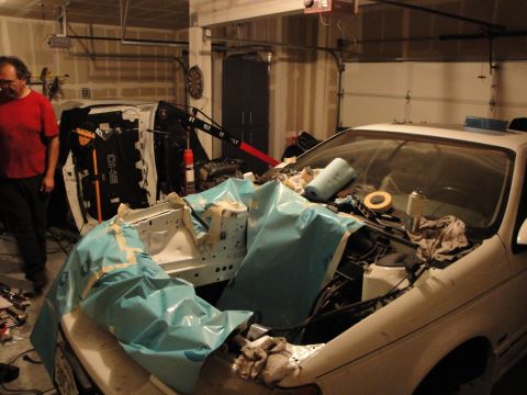 1989 Ford Taurus - A car's engine bay is covered in protective sheeting, suggesting ongoing work or recent work.