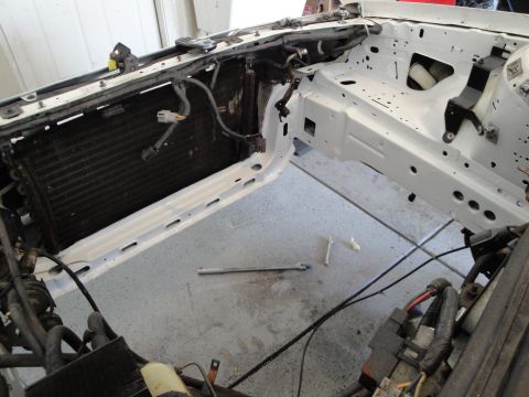 1989 Ford Taurus - Engine bay of a car undergoing restoration, with the radiator exposed and frame rails painted white.