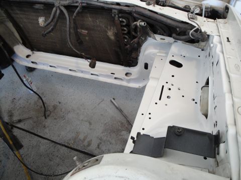 1989 Ford Taurus - The engine bay of a white vehicle is shown with the radiator and some components removed, revealing the internal structure.
