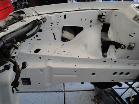1989 Ford Taurus - The engine bay of a vehicle is shown after being painted white, with various components and wiring present.