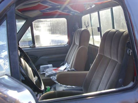 1995 Ford F-150 - The interior of a pickup truck shows cloth seats, a steering wheel, and a distinctive headliner design.
