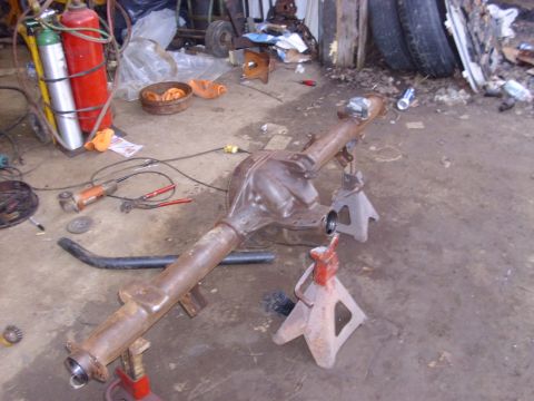 1995 Ford F-150 - Rear axle assembly on jack stands, surrounded by tools and equipment in a workshop.