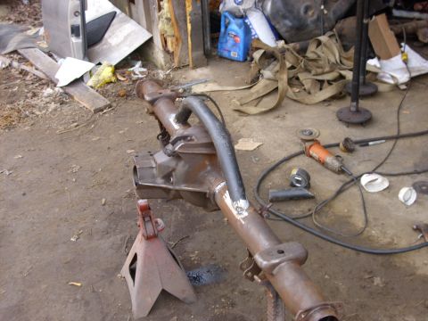 1995 Ford F-150 - Differential axle assembly supported by jack stands, with tools and straps nearby.