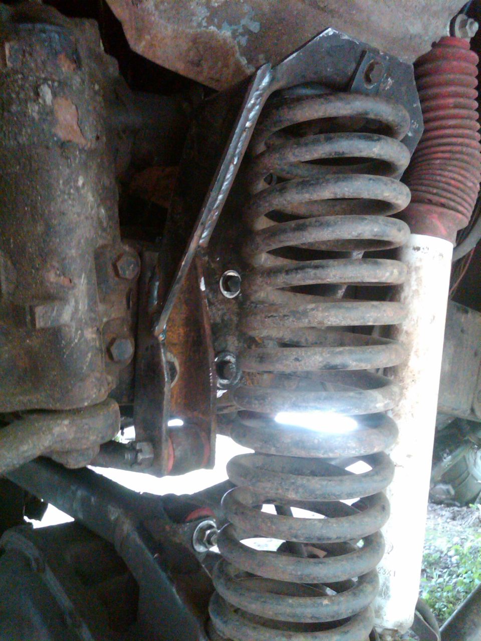 I spliced the cut side of the coil bucket to the track bar bracket with a chunk I cut out of the old coil bucket.