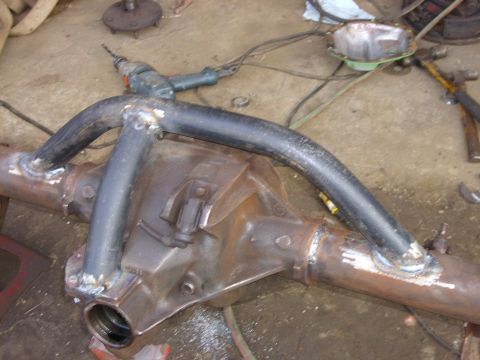 1995 Ford F-150 - A modified rear axle assembly with welded tubing is shown on a concrete floor with tools nearby.