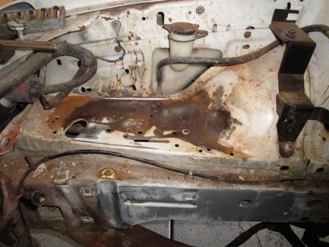 1989 Ford Taurus - The engine bay shows significant rust and corrosion on various metal components.
