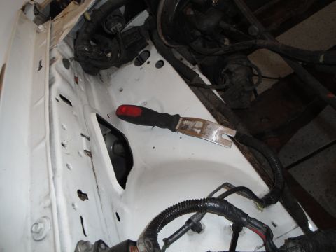 1989 Ford Taurus - Close-up view of a vehicle's engine bay, showing wiring and a tool.