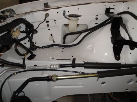 1989 Ford Taurus - Close-up view of the engine bay, showing various hoses and wiring, likely during a repair or modification.