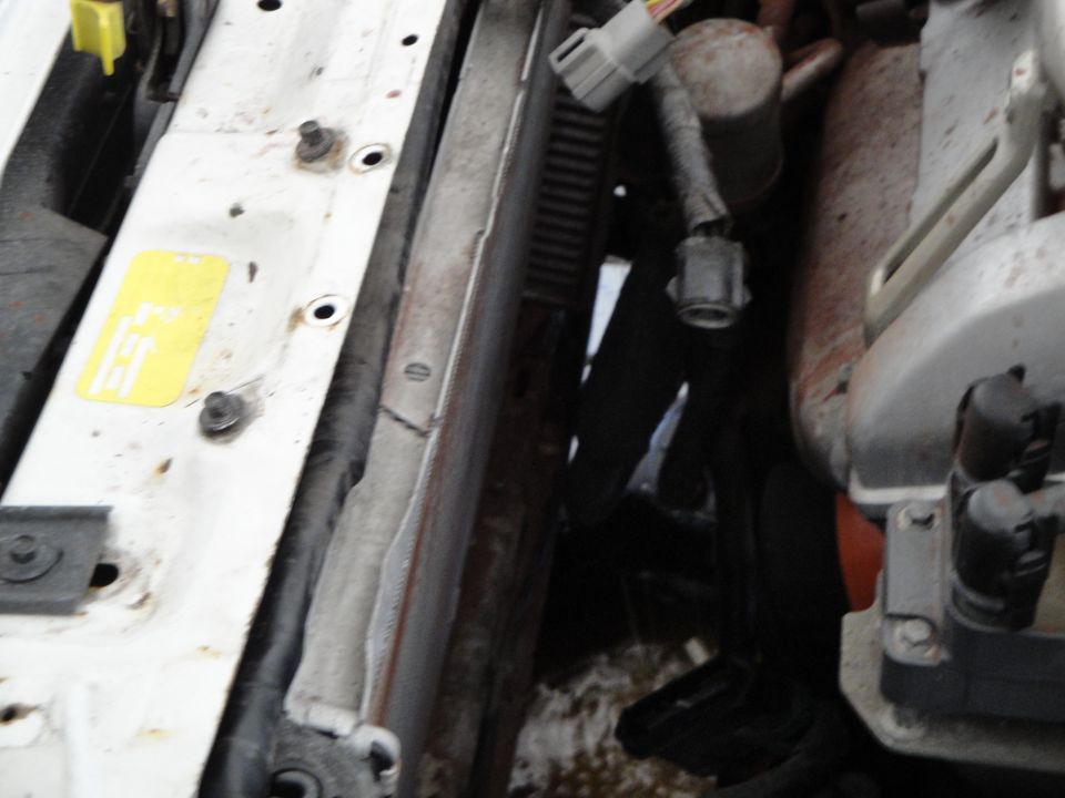 Close-up of engine bay showing radiator, hoses, and wiring