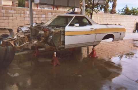 1972 Ford Ranchero - A 1972 Ford Ranchero is elevated on jack stands with its front end disassembled, undergoing work.