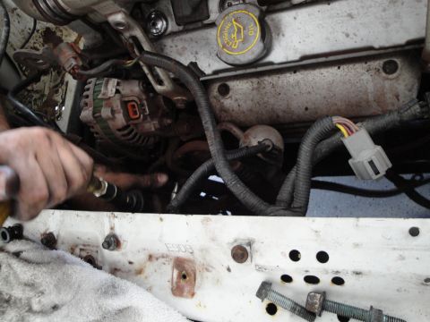 1989 Ford Taurus - Close-up view of an engine bay, showing an alternator and various electrical components.