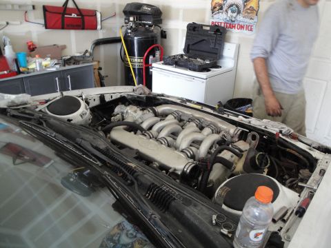 1989 Ford Taurus - Mechanic working on the engine bay of a 1989 Ford Taurus.