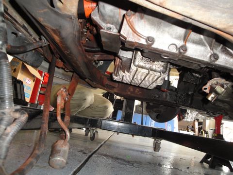 1989 Ford Taurus - The underside of a vehicle's engine and transmission assembly is visible, undergoing maintenance.
