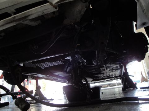 1989 Ford Taurus - Car is on jack stands, showing the underside and suspension components.