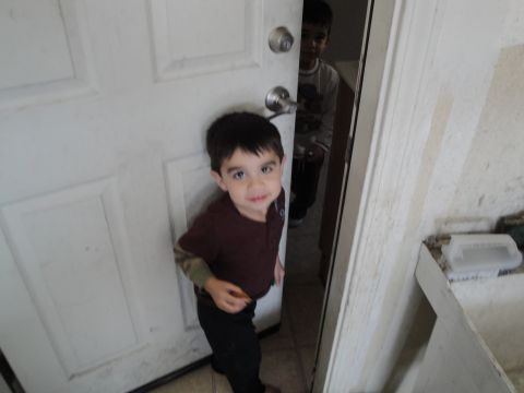 1989 Ford Taurus - Two young boys are visible in a doorway, with one child in the foreground looking directly at the camera.