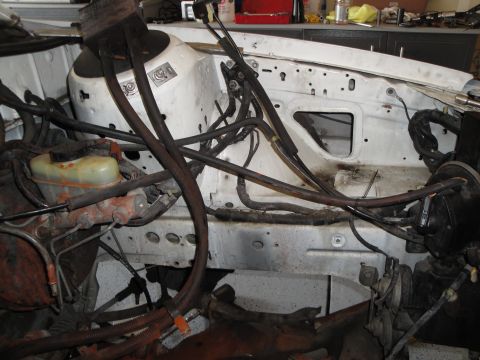 1989 Ford Taurus - The engine bay of a vehicle is shown, with a focus on the brake master cylinder and associated plumbing and wiring.