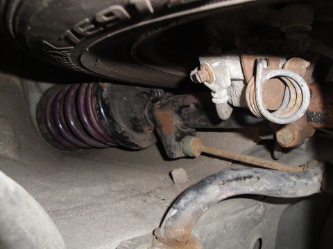 1989 Ford Taurus - Rear suspension components including a purple coil spring and sway bar are visible in this close-up shot.