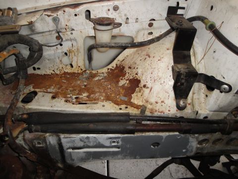 1989 Ford Taurus - Rust damage is evident in the engine bay, affecting the inner fender and strut tower area.