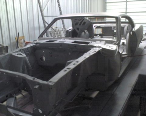 1970 Ford Mustang - The bare metal body of a 1970 Ford Mustang is shown in a workshop, ready for restoration.