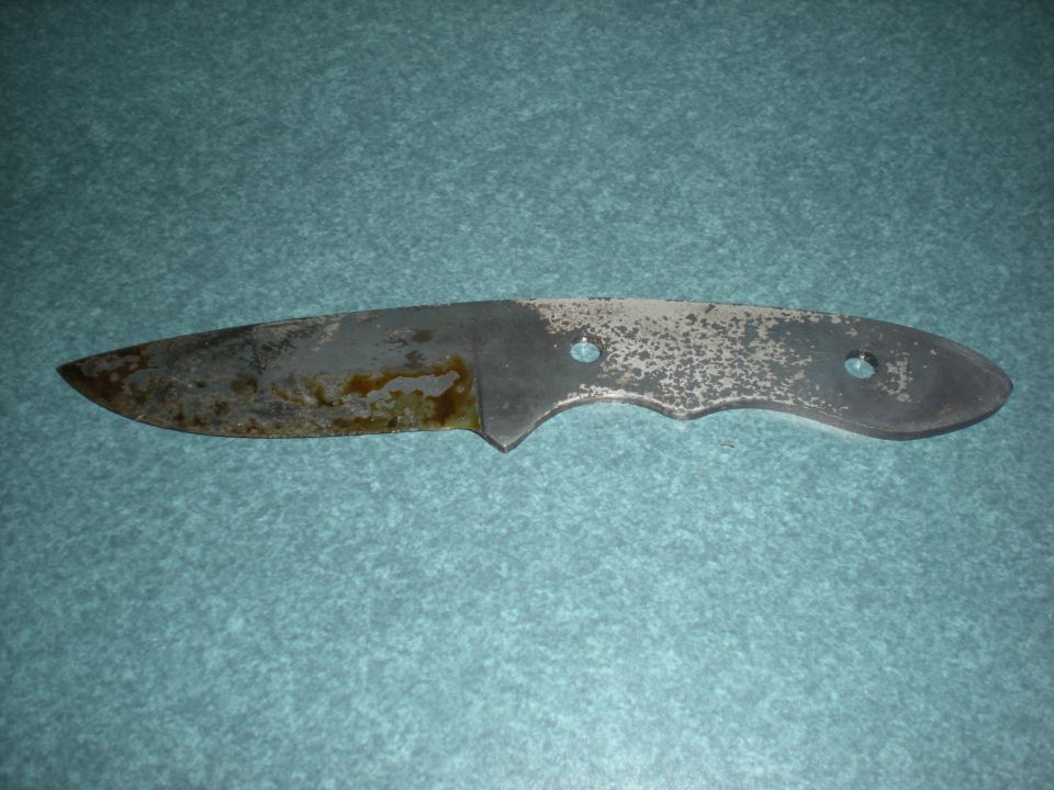 Unfinished knife blade with rust and pitting, showing two handle mounting holes