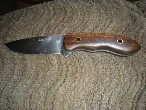 1974 Ford Ranchero - A knife with a wooden handle and a steel blade is shown against a carpeted background.