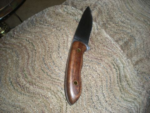 1974 Ford Ranchero - A knife with a wooden handle and a dark metal blade is shown resting on a textured surface. The Supermotors logo is visible in the lower ri…