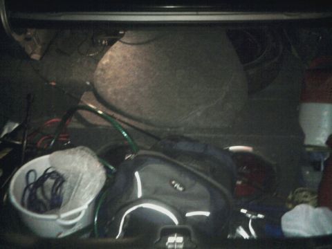 1996 Mercury Grand Marquis - The trunk of a 1996 Mercury Grand Marquis contains a spare tire, a duffel bag, and a bucket of cables.