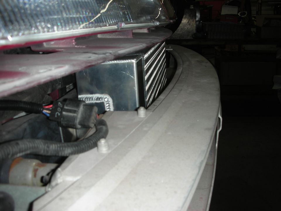 Close-up of intercooler installation with visible wiring and bumper